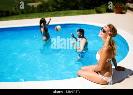 Friends playing ball games in pool Stock Photo