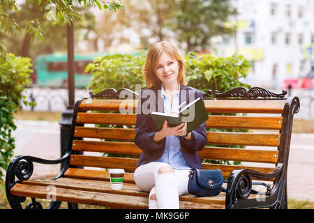 Young woman studying and writing in a park. Stock Photo