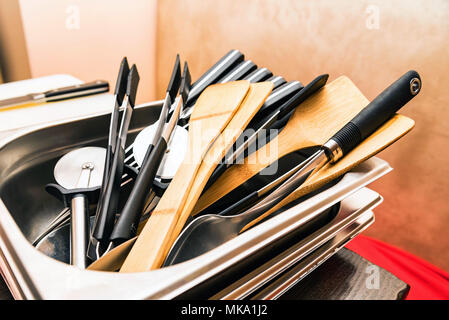 Wooden and plastic kitchen tools lie in tray Stock Photo