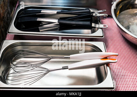 Metal and plastic kitchen tools lie in tray Stock Photo