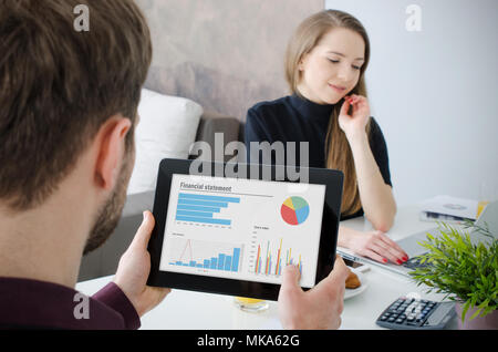 Analyst working with statistics. Businessman working at home with tablet Stock Photo