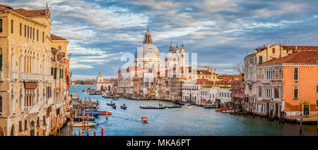 Classic view of famous Canal Grande with scenic Basilica di Santa Maria della Salute in beautiful golden evening light at sunset, Venice, Italy Stock Photo