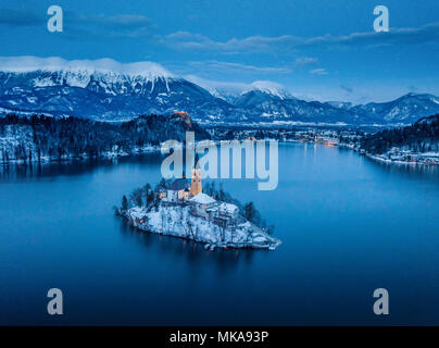 Beautiful aerial twilight view of Lake Bled with famous Bled Island and historic Bled Castle in the background during scenic blue hour at dawn in wint Stock Photo