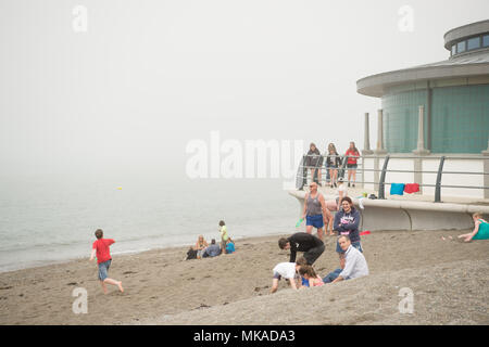 Aberystwyth  Wales UK, Monday 07 May 2018  UK Weather: People at the seaside in Aberystwyth in the chilly  and grey sea mist, on what is expected to be the hottest early May Bank Holiday Monday on record, with temperatures reaching 28ºc in parts of the south east of England   photo © Keith Morris / Alamy Live News Stock Photo