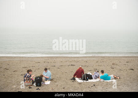 Aberystwyth  Wales UK, Monday 07 May 2018  UK Weather: People at the seaside in Aberystwyth in the chilly  and grey sea mist, on what is expected to be the hottest early May Bank Holiday Monday on record, with temperatures reaching 28ºc in parts of the south east of England   photo © Keith Morris / Alamy Live News Stock Photo