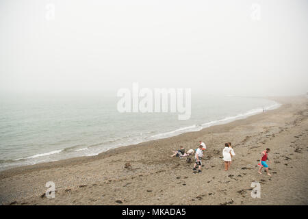 Aberystwyth  Wales UK, Monday 07 May 2018  UK Weather: People at the seaside in Aberystwyth in the chilly  and grey sea mist, on what is expected to be the hottest early May Bank Holiday Monday on record, with temperatures reaching 28ºc in parts of the south east of England   photo © Keith Morris / Alamy Live News Stock Photo