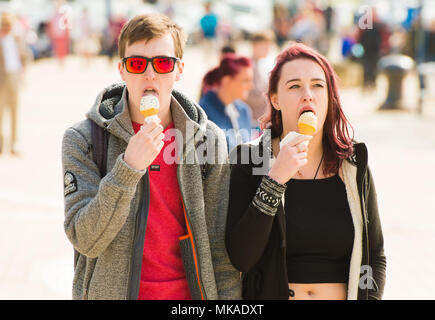 Aberystwyth  Wales UK, Monday 07 May 2018  UK Weather: After hours of chilly grey sea mists, the sun finally shone through on this young couple eating icecream as they walk along the promenade at the seaside in Aberystwyth, , on what is expected to be the hottest early May Bank Holiday Monday on record, with temperatures reaching 28ºc in parts of the south east of England   photo © Keith Morris / Alamy Live News Stock Photo