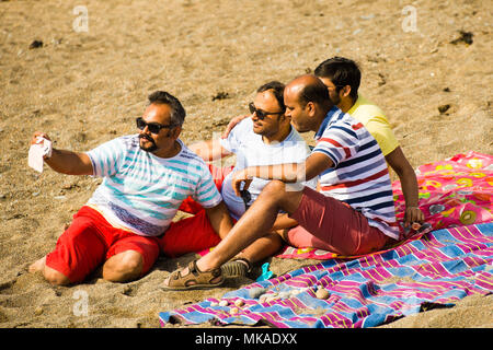 Aberystwyth  Wales UK, Monday 07 May 2018  UK Weather: After hours of chilly grey sea mists, the sun finally shone through on this group of men taking a selfie picture at the beach in Aberystwyth, , on what is expected to be the hottest early May Bank Holiday Monday on record, with temperatures reaching 28ºc in parts of the south east of England   photo © Keith Morris / Alamy Live News Stock Photo