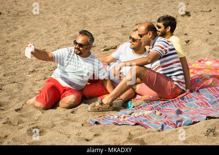 Aberystwyth  Wales UK, Monday 07 May 2018  UK Weather: After hours of chilly grey sea mists, the sun finally shone through on this group of men taking a selfie picture at the beach in Aberystwyth, , on what is expected to be the hottest early May Bank Holiday Monday on record, with temperatures reaching 28ºc in parts of the south east of England   photo © Keith Morris / Alamy Live News Stock Photo