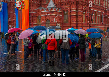MOSCOS, RUSSIA- APRIL, 24, 2018: Outdoor view of unidentified people with umbrellas protecting from rain walking close to the State Historical Museum on red square in Moscow Stock Photo