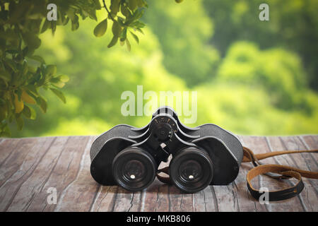 vintage binoculars on wood table in nature Stock Photo