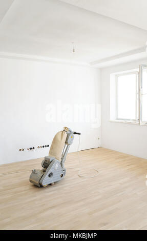 The grinding machine for wooden parquet floors on a oak parquet. Stock Photo