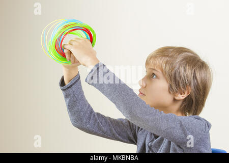 Boy holding colorful filaments for 3d pen. Stock Photo