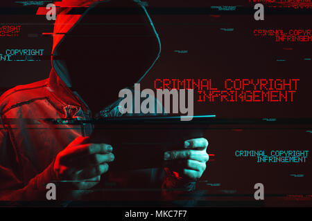 Criminal copyright infringement concept with faceless hooded male person, low key red and blue lit image and digital glitch effect Stock Photo