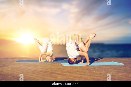 couple doing yoga headstand outdoors Stock Photo