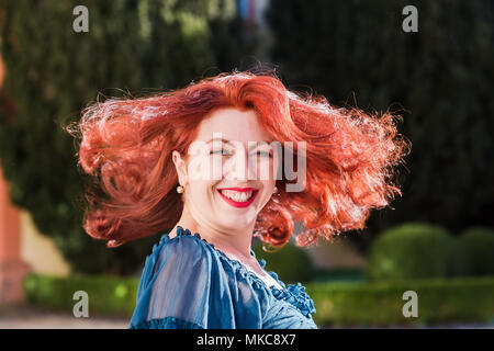 smiling redheaded beautiful woman turns her head Stock Photo
