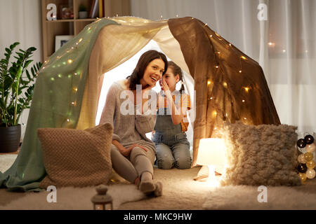 happy family whispering in kids tent at home Stock Photo