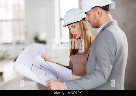 architects with blueprint and helmets at office Stock Photo