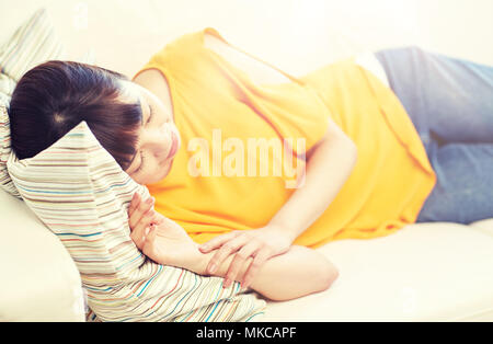 happy asian teenage girl sleeping on sofa at home Stock Photo
