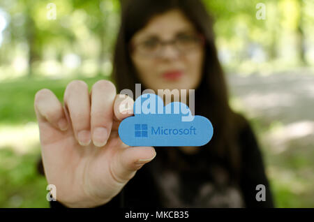 Nis, Serbia, April 24, 2018:  woman on blurred background reach out  holding Microsoft Windows OneDrive icon, outdoor in park Stock Photo