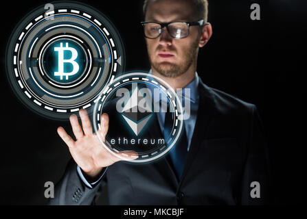 businessman with ethereum and bitcoin holograms Stock Photo