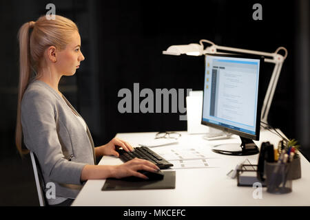 female programmer working late at night office Stock Photo