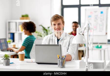 creative male office worker with laptop Stock Photo