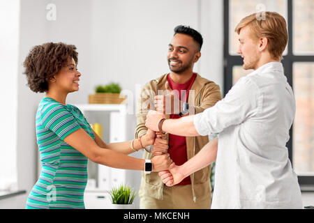 happy creative team making high five at office Stock Photo
