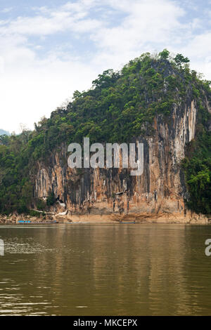 View of the Mekong River and limestone cliff where the famous Pak Ou Caves are set. They are located near Luang Prabang in Laos. Stock Photo