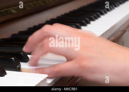 Close up of a woman's hand playing piano with motion blur Stock Photo