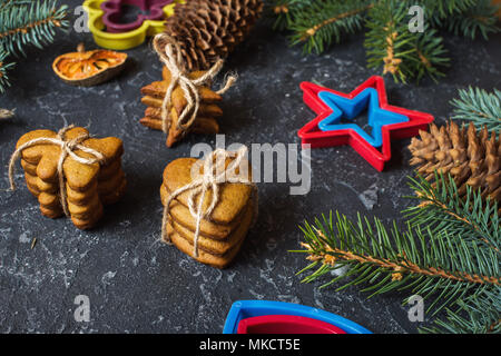 Christmas gingerbread cookies and fir tree and cones on dark stone background Stock Photo