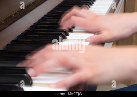 Close up of woman's hands playing piano with motion blur Stock Photo
