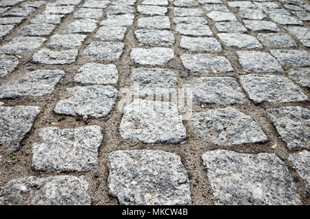 Close up picture of an old cobblestone street, selective focus on the front. Stock Photo