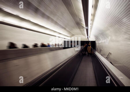 Blurry motion image of people on escalators in subway station in Paris. Stock Photo