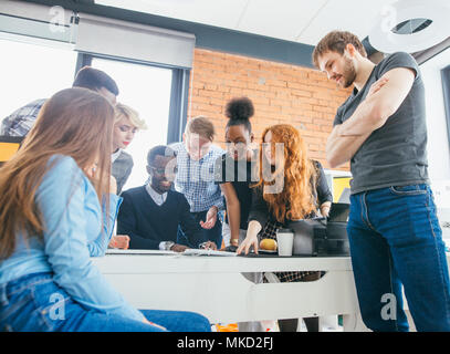 young workers controlling the work of their new collegue in the stydio with loft style Stock Photo