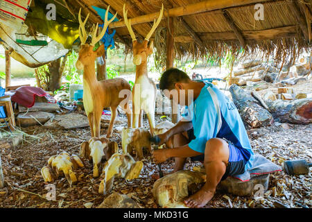 Lampang, Thailand - November 3, 2012: Craftsman craving a piece of wood to make deer sculpture for furniture in the workshop in Lampang, Thailand Stock Photo