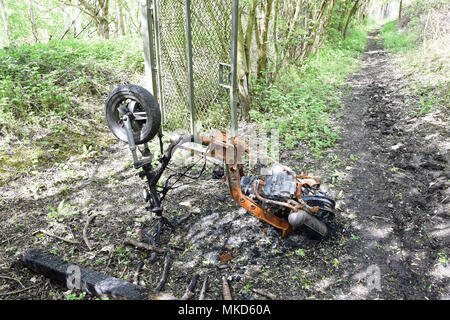 A burnt-out motorbike on a public footpath in Buckinghamshire, UK Stock Photo