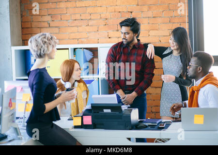 business comunication. conversation among mixed race office workers in casual clothes in the office building. Stock Photo