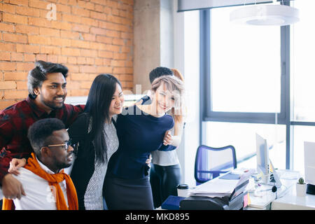 hugging team is chatting online with colleagues on the Net Stock Photo