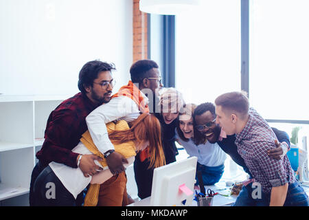 mixed race startup team holding each other in a tender embrace Stock Photo