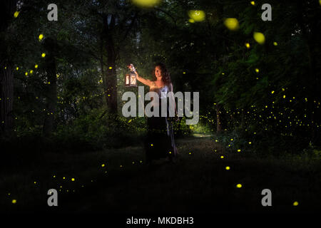 A girl is looking for the fireflies on a forest near the Po river in Italy