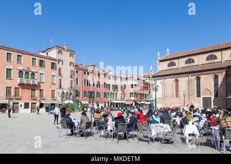 Tourists eating at a restaurant in Campo Santo Stefano, San Marco, Venice, Italy enjoying the spring sunshine Stock Photo