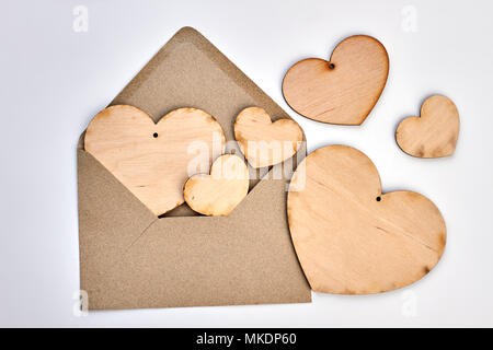 Opened envelope and plywood hearts. Vintage style envelope and wooden hearts on white background. Happy Valentines Day. Stock Photo
