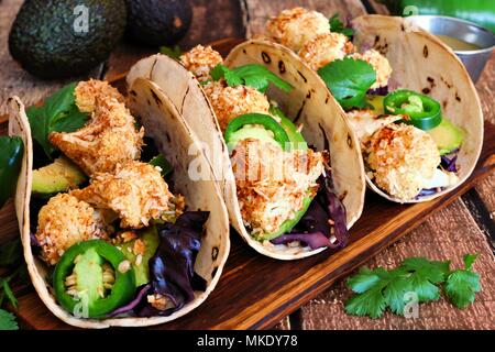 Roasted coconut cauliflower tacos. Healthy, vegan meal. Close up, side view on a wooden background. Stock Photo