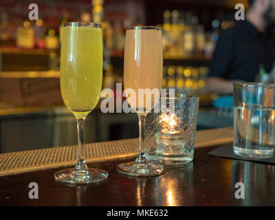 Two wineglasses filled with mimosa drinks sitting on a bar counter top during brunch Stock Photo