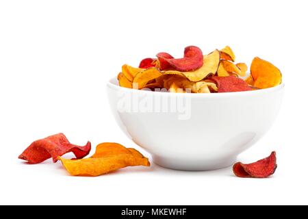 Bowl of mixed healthy vegetable chips. Side view, isolated on a white background. Stock Photo