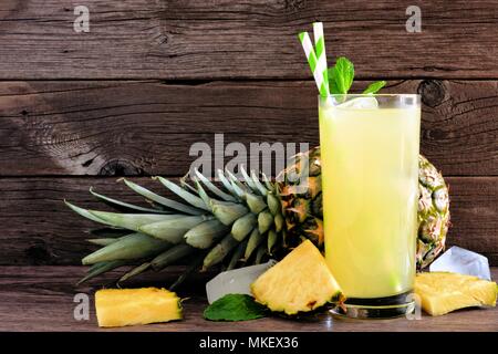 Glass of pineapple juice. Side view on a rustic wood background, Stock Photo