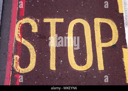city centre traffic control zones stop sign in yellow with red lines on red tarmac Stock Photo