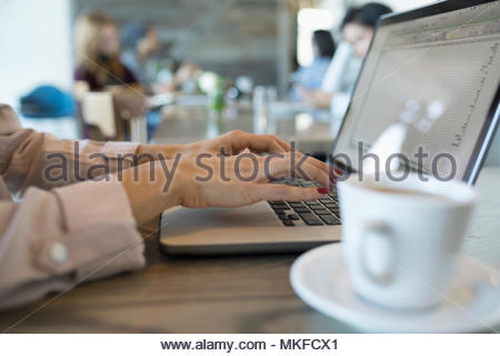 Close up businesswoman typing, working at laptop in cafe