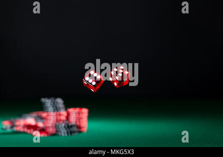 tumbling dice showing various numbers.  Craps, casino chips action and room in frame for copy space Stock Photo